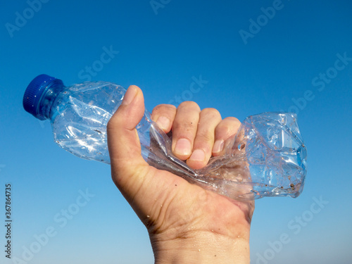 Beach plastic bottle is holding in female hand