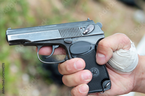 Pistol, small arms close-up in the hands of a policeman.
