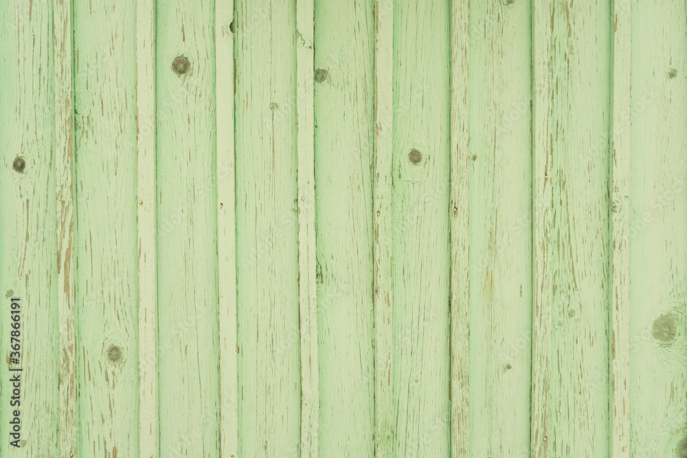 Old green wooden planks in the village. Vintage countryside fence. Rustic texture background.