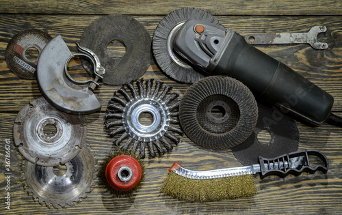 angle grinder with different discs and tools on the old wooden background