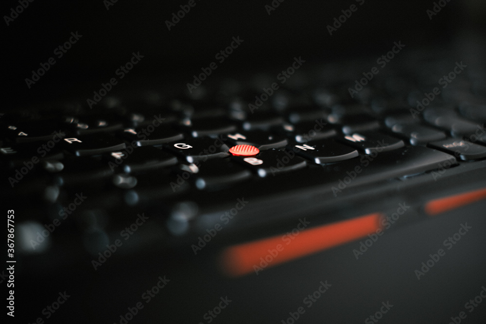close up of a computer keyboard and trackpoint - red trackpoint on Thinkpad laptop 