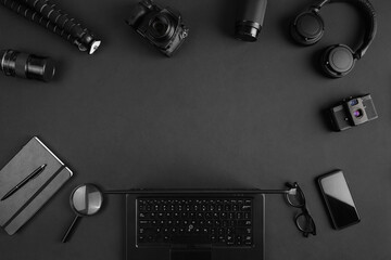 Photogrpahers aor retouchers gear arranged on abstract black background in border frame