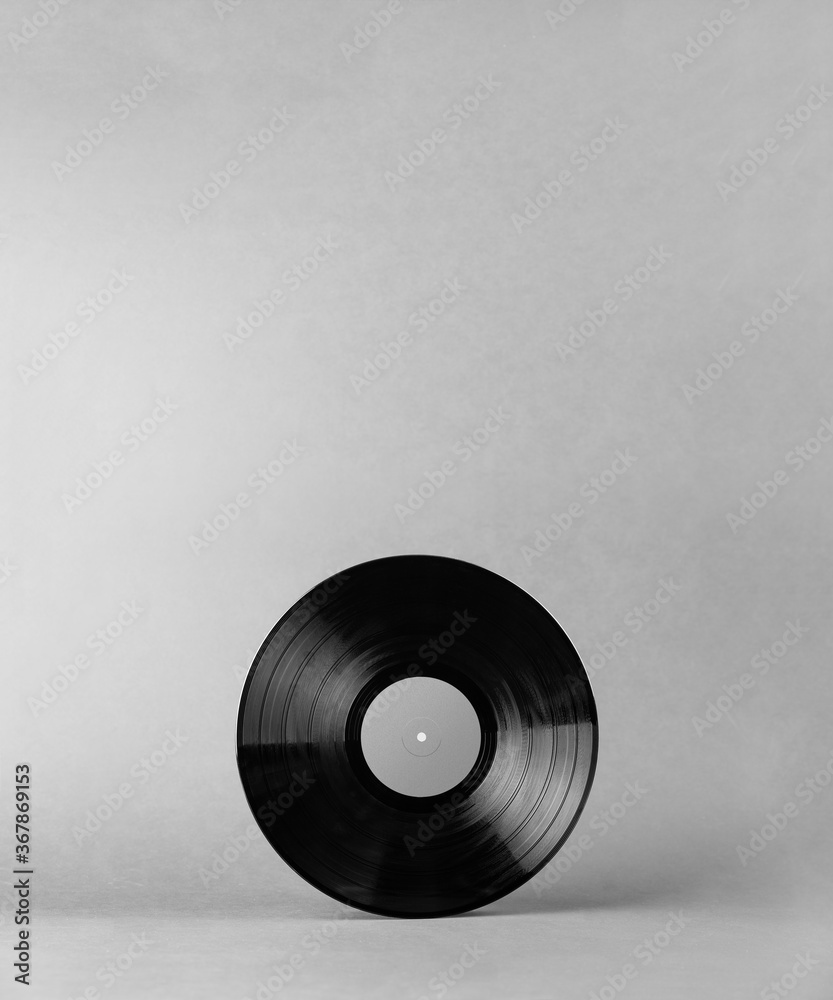 Obraz premium Black vinyl music record isolated on abstract gray background with shadows and empty space