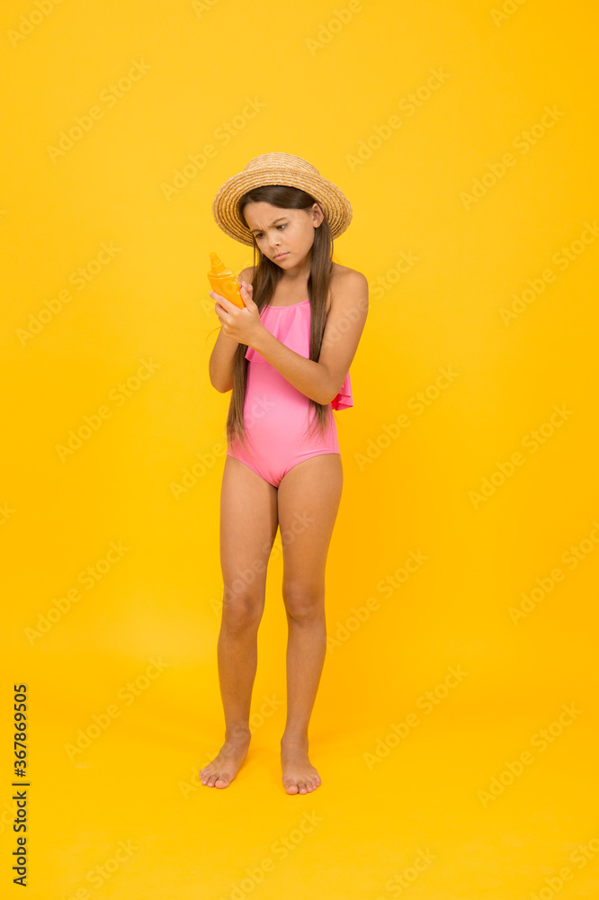 Small girl in swimsuit hold sunscreen cosmetics cream, composition of cosmetic concept Small girl in swimsuit hold sunscreen cosmetics cream, composition of cosmetic concept