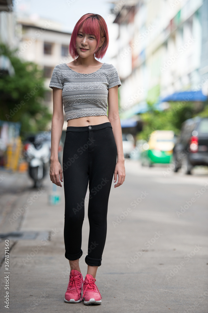 Young beautiful Asian woman with pink hair outdoors Young beautiful Asian woman with pink hair outdoors