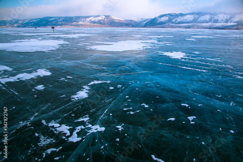 Lake Baikal in winter. Beautiful view of frozen water. Textured blocks of clear blue ice. Mountains and icy texture landscapes. Observation of wild world. Adventure on lake Baikal, Russia