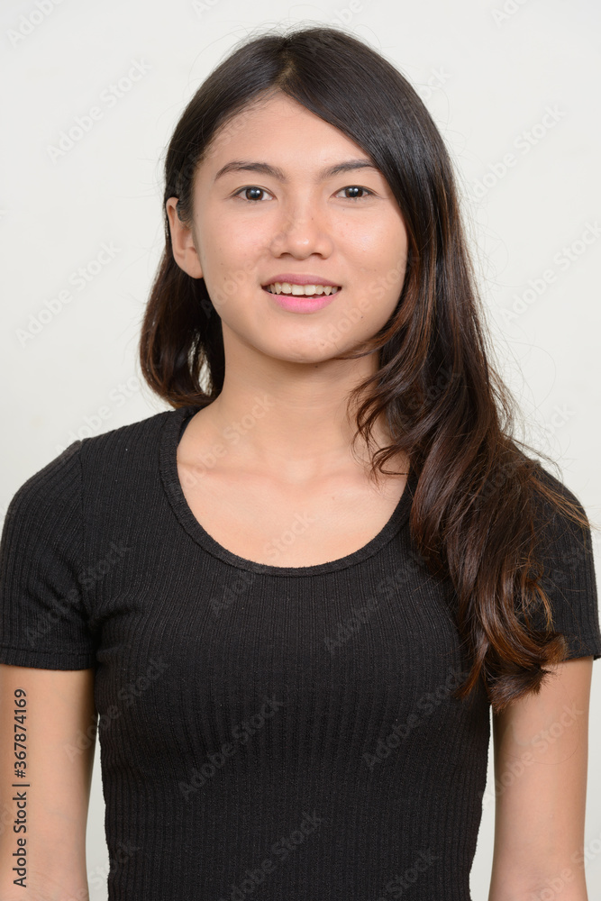 Portrait of happy young beautiful Asian woman smiling