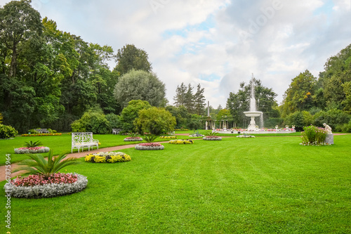 Foto A peaceful garden with flowers, water fountain and bench near Catherine's Garden and Palace at Pushkin, Saint Petersburg, Russia