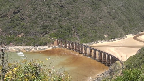 HD summer day video of Kaaimans River Railway Bridge, white sand beach, Kaaimans River mouth. Bridge is located near seaside holiday resort Wilderness in Garden Route, Western Cape, South Africa photo