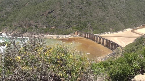 HD summer day video of Kaaimans River Railway Bridge, white sand beach, Kaaimans River mouth. Bridge is located near seaside holiday resort Wilderness in Garden Route, Western Cape, South Africa photo