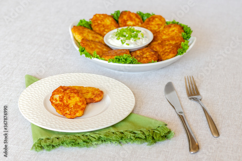 Draniki, hash browns or potato pancakes served with fresh cream and green onions 