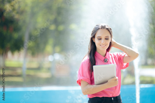 Woman with Pc Tablet in Front of Urban Artesian Fountain
