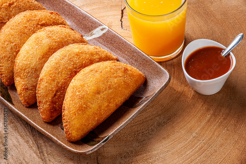 Brazilian appetizer deep fried beef croquette with pepper sauce and orange juice - Risolis photo