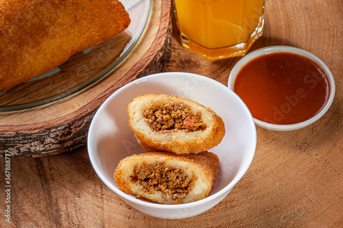 Brazilian appetizer deep fried beef croquette with pepper sauce and orange juice - Risolis photo