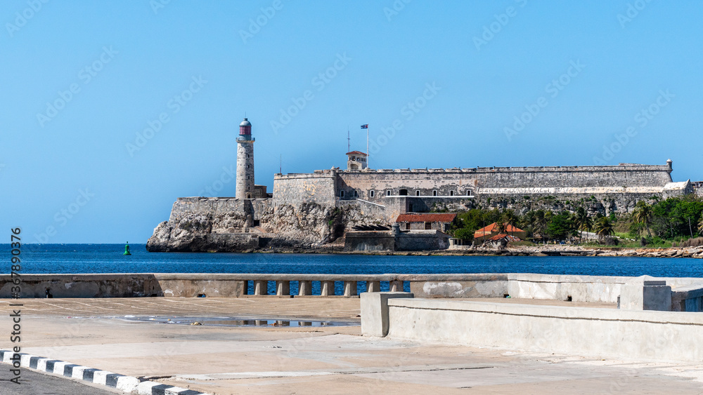 Havana, Cuba. Vibrant streets of the capital with el Morro fortress in the background, lighthouse of La Cabana Fort.