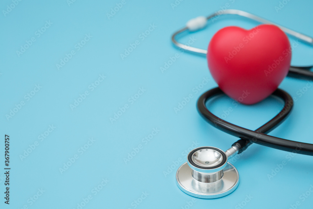 Heart shaped squeeze ball for hand muscle exercise and stethoscope on blue background and copy space Heart shaped squeeze ball for hand muscle exercise and stethoscope on blue background and copy space