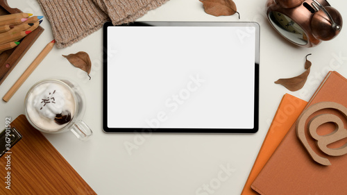 Digital tablet with clipping path on autumn workspace with supplies and decorations