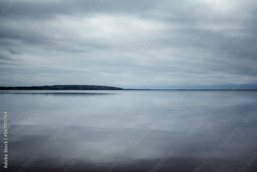 Mirror surface of the lake with the sky reflected in it. Beautiful Karelian landscape. Space for text.