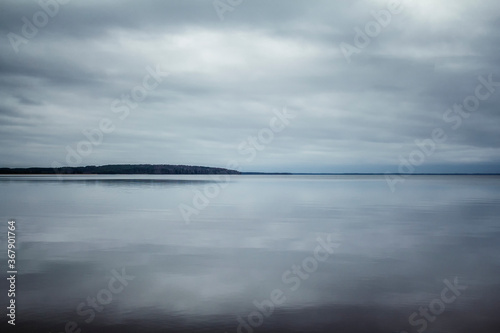Mirror surface of the lake with the sky reflected in it. Beautiful Karelian landscape. Space for text.