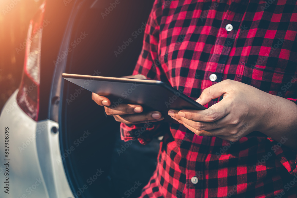 Young woman read a book on a tablet at car on road tranquil scene.