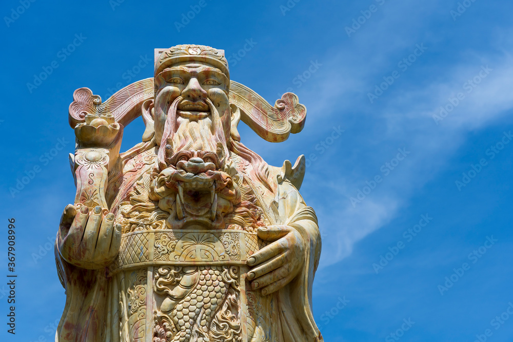 Fototapeta premium Face of an ancient Chinese warrior statue or god Chinese in a Buddhist temple in the city of Danang, Vietnam