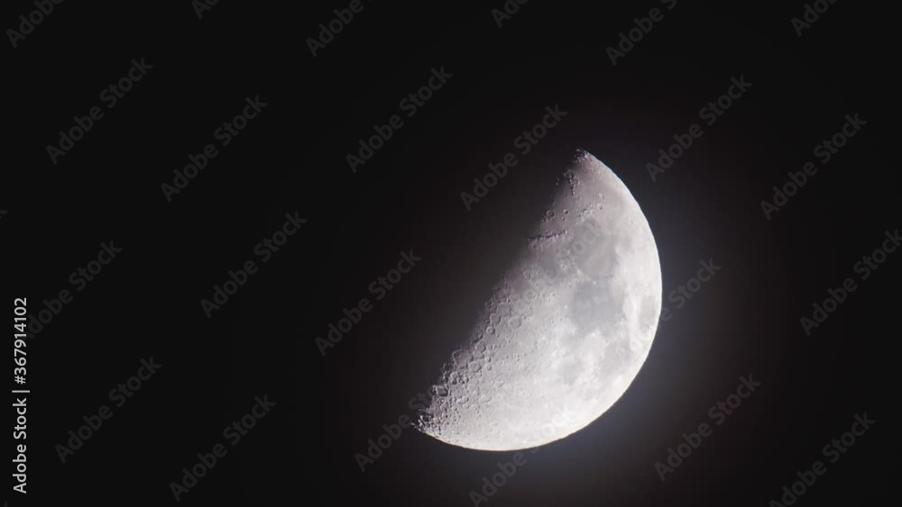 Moon lit up on night sky with shadow on side Moon lit up on night sky with shadow on side