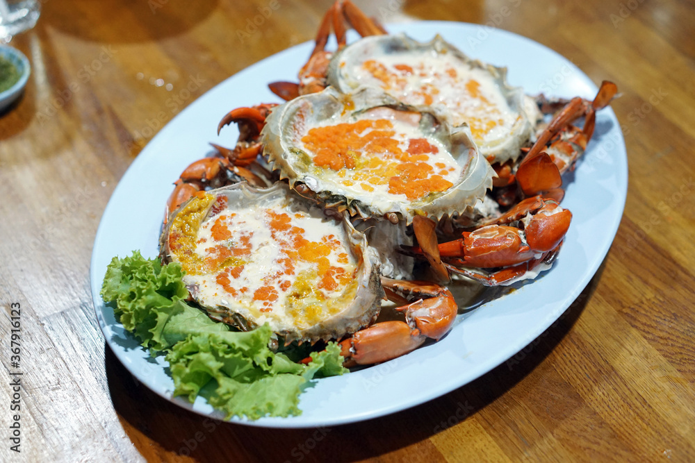 Boiled crab egg with milk - A plate of steamed black crab with crab's spawn (roe) and claw, Thai style seafood.