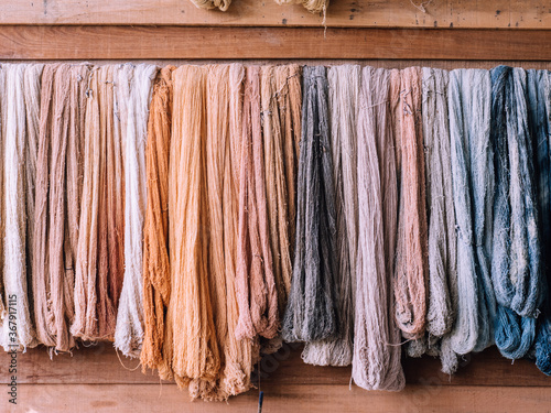 Dyed cotton yarns by nature colors hanging on wooden wall