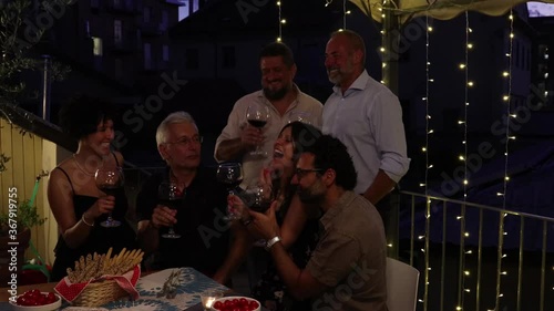 six italian friends toast with red winw immersed in a magical atmosphere photo