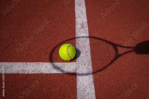 Shadow of net and racket surrounding a tennis ball © NetPix