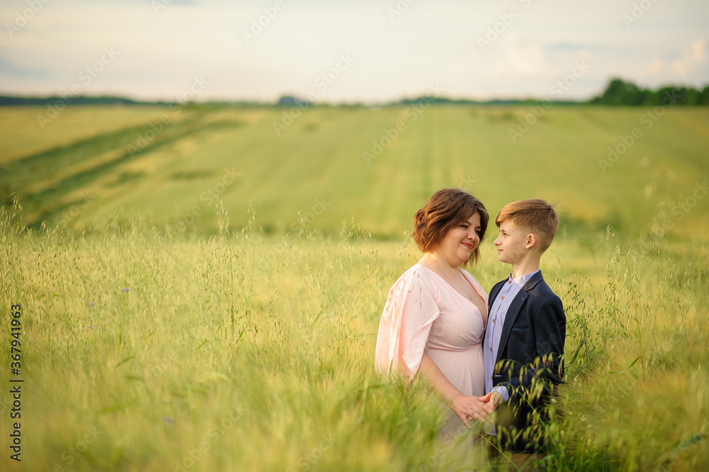 Mother and son in a green wheat field. Both hold the hand. Mother and son in a green wheat field. Both hold the hand.
