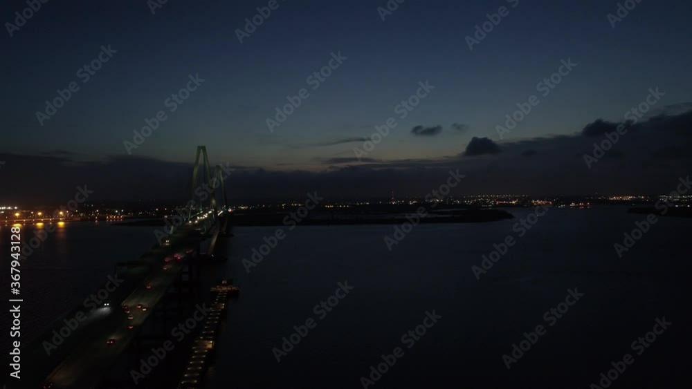 Drone video of cars driving on a suspension bridge over a large body of water. Drone video of cars driving on a suspension bridge over a large body of water.