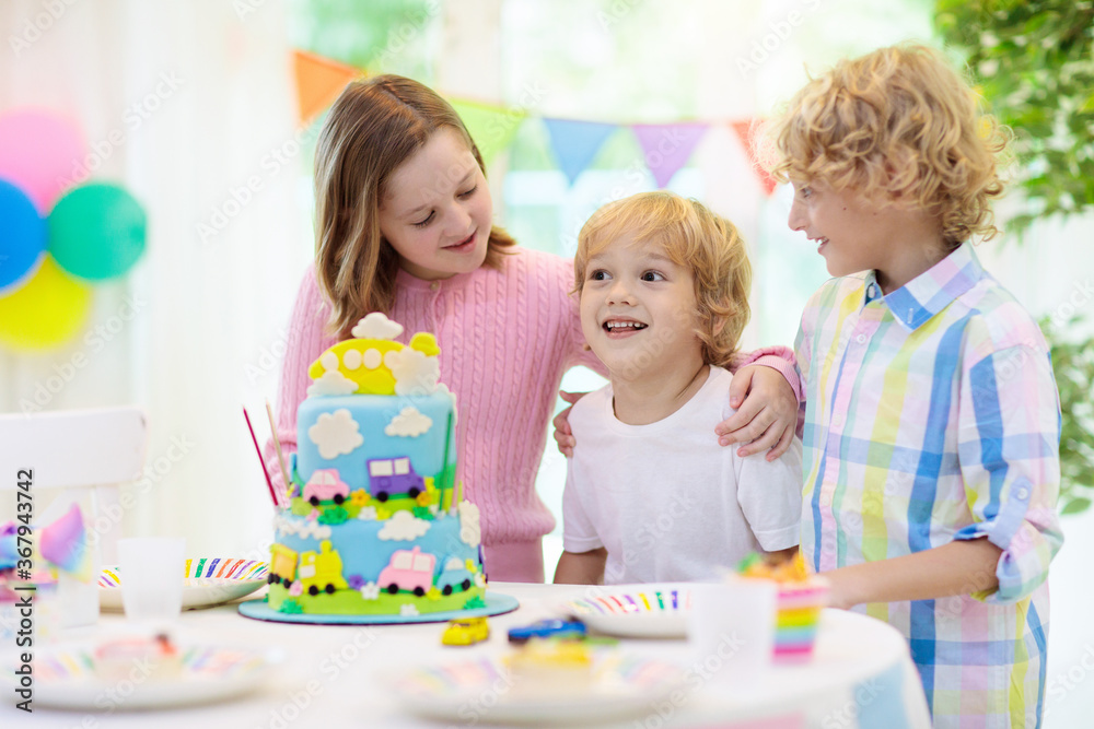 Kids birthday party. Child blowing out cake candle Kids birthday party. Child blowing out cake candle