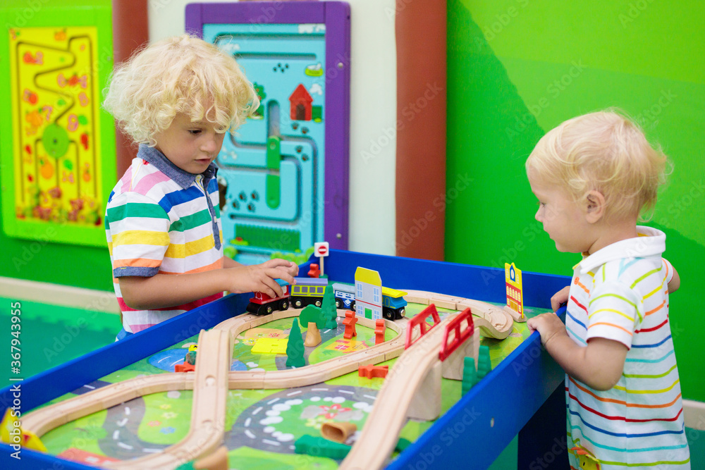 Fototapeta premium Kids play wooden railroad. Child with toy train.