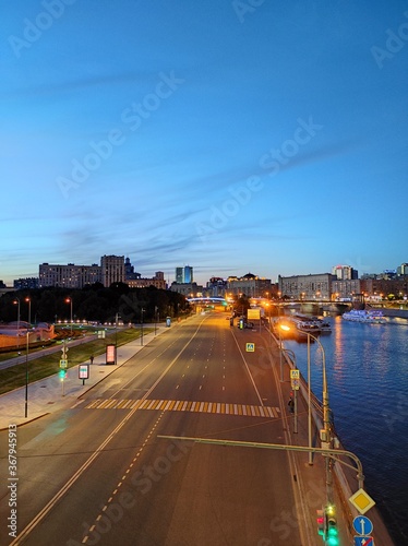 Top view of the empty road at night city Moscow  Russia. Pedestrians walk along the sidewalk. The road near the river with ships.