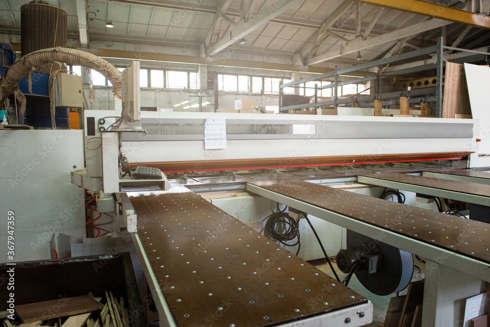 Wooden furniture production. Industrial cutting machine for automatic wood  cutting Stock Photo | Adobe Stock