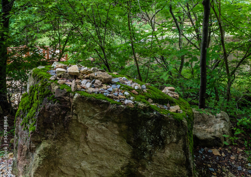 Small rocks and stones on top of moss covered boulder Small rocks and stones on top of moss covered boulder