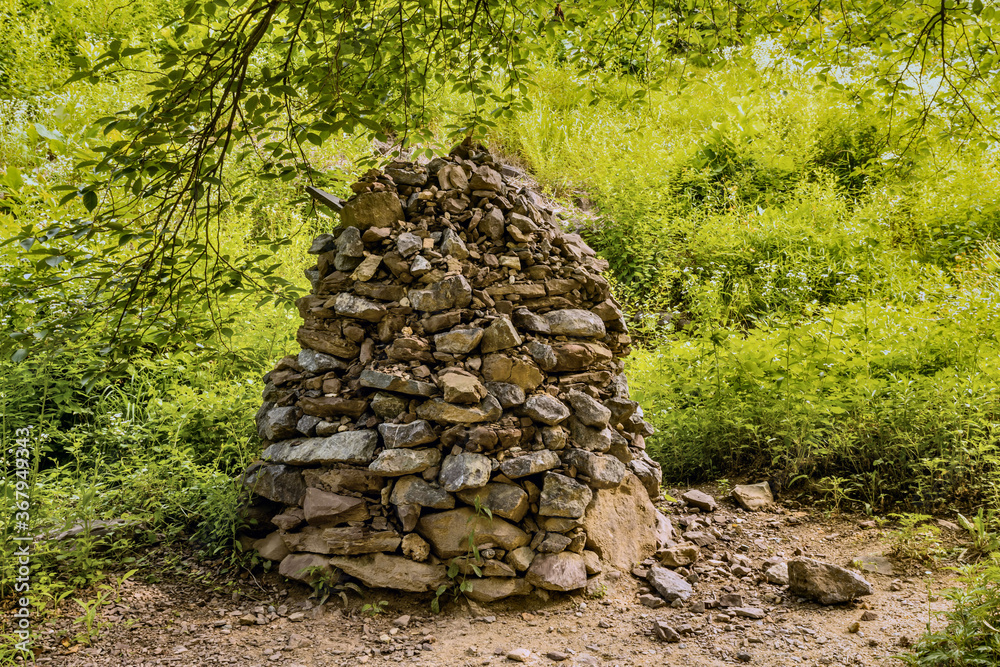 Column of stones and pebble stacks beside hiking trail