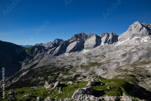 top of the alps mountain with a little green grass and snow in the summer