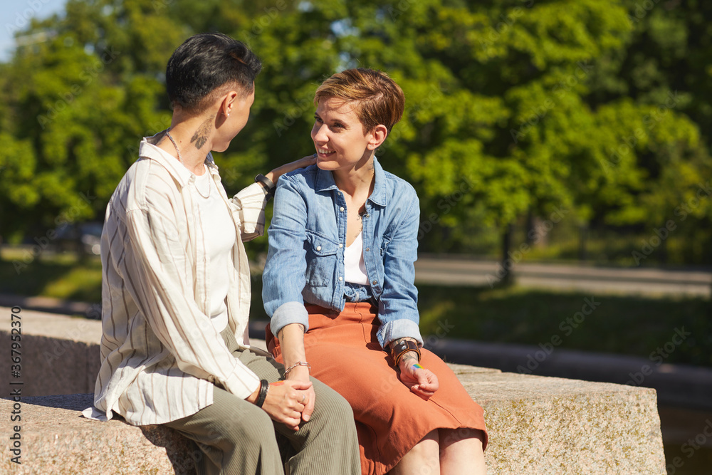Two young women have meeting in the park they sitting and talking to each other Two young women have meeting in the park they sitting and talking to each other