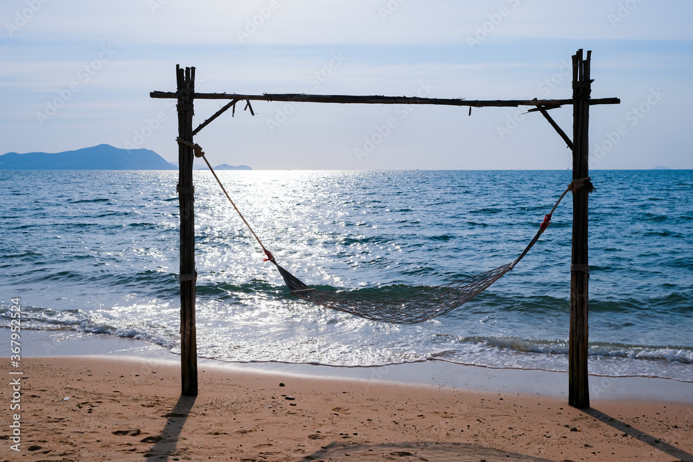 Romantic cozy hammock on the tropical beach by the sea. Peaceful seascape. Relax, travel concept, travelling.