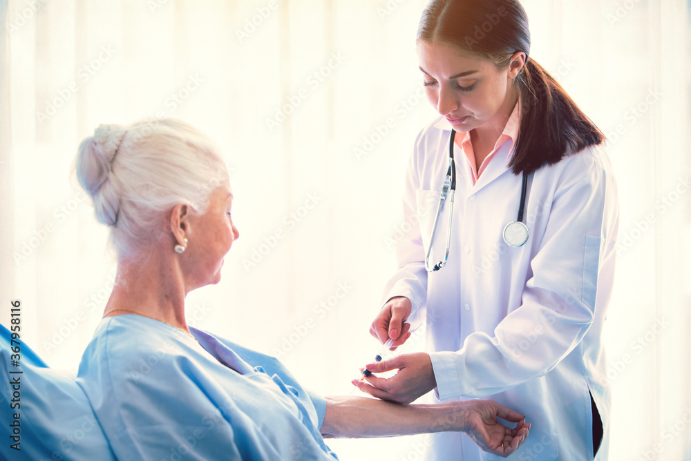 Woman doctor giving injection needle vaccine to elderly patient at room in hospital. Healthcare homecare concept. Vintage tone Woman doctor giving injection needle vaccine to elderly patient at room in hospital. Healthcare homecare concept. Vintage tone