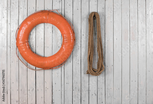 orange marine lifebuoy on white wooden background