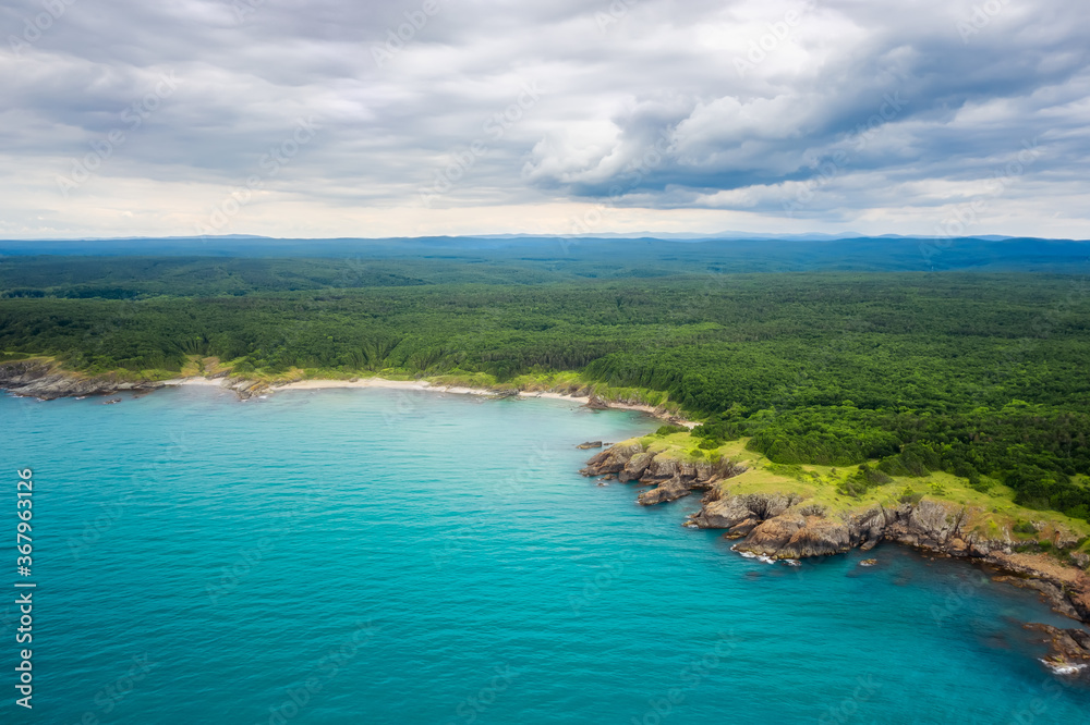 Aerial panoramic view of the wild beaches, surrounded by rocks and green dense forests on the southern Black Sea coast, Bulgaria.