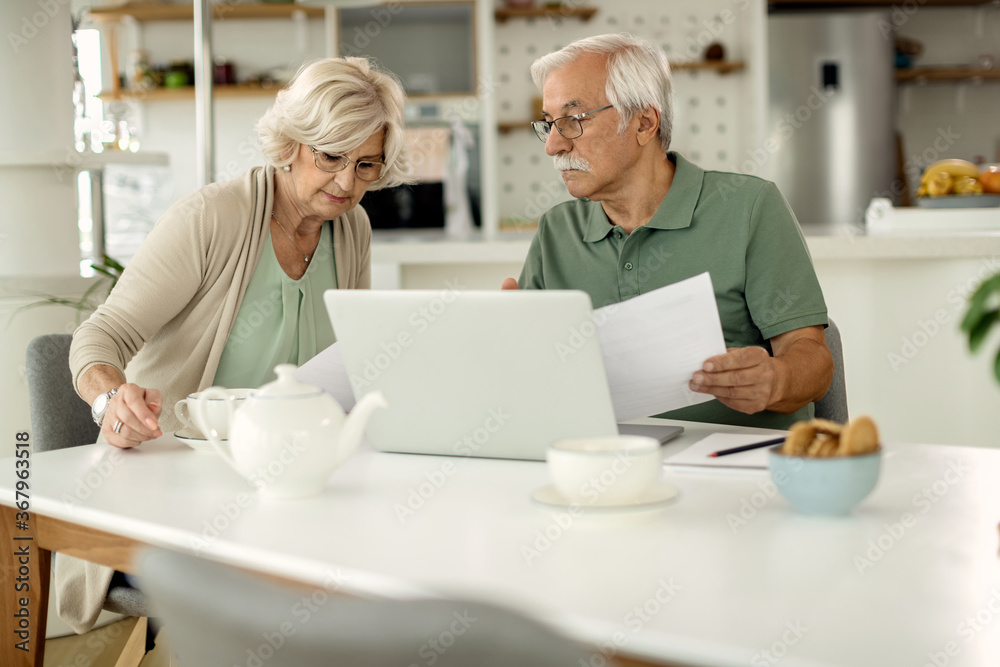 Senior couple going through their financial bills at home. Senior couple going through their financial bills at home.