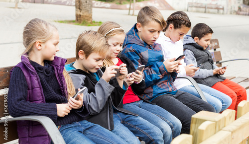 Preschool children sitting on a bench in favor of the Internet