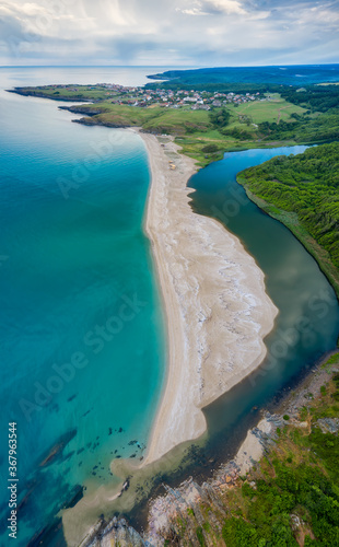 An empty wild beach, surrounded by rocks and green thick forests. Aerial view with beautiful, wild beach at the Black Sea coast and the estuary of Veleka river, Bulgaria. © Jess_Ivanova