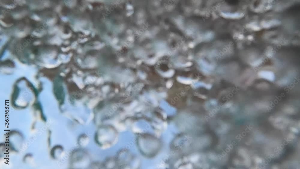 Effervescent clear fresh water bubbles moving and colliding in pool on bright blue sunny sky day, underwater close up low angle perspective looking up Effervescent clear fresh water bubbles moving and colliding in pool on bright blue sunny sky day, underwater close up low angle perspective looking up