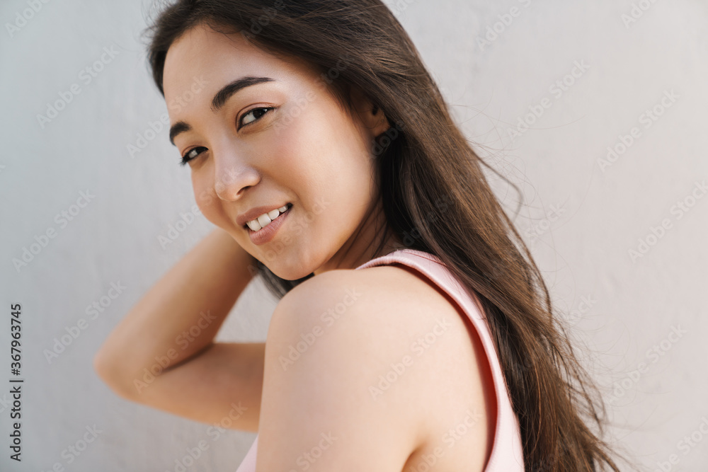Image of joyful asian beautiful girl smiling at camera Image of joyful asian beautiful girl smiling at camera