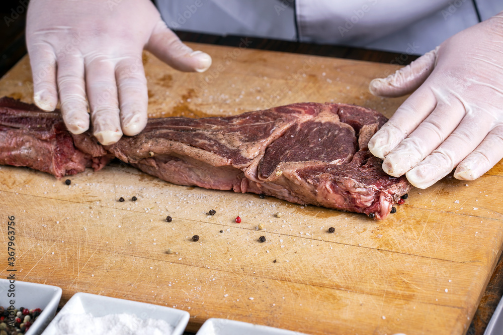 The chef prepares meat steak in his hands